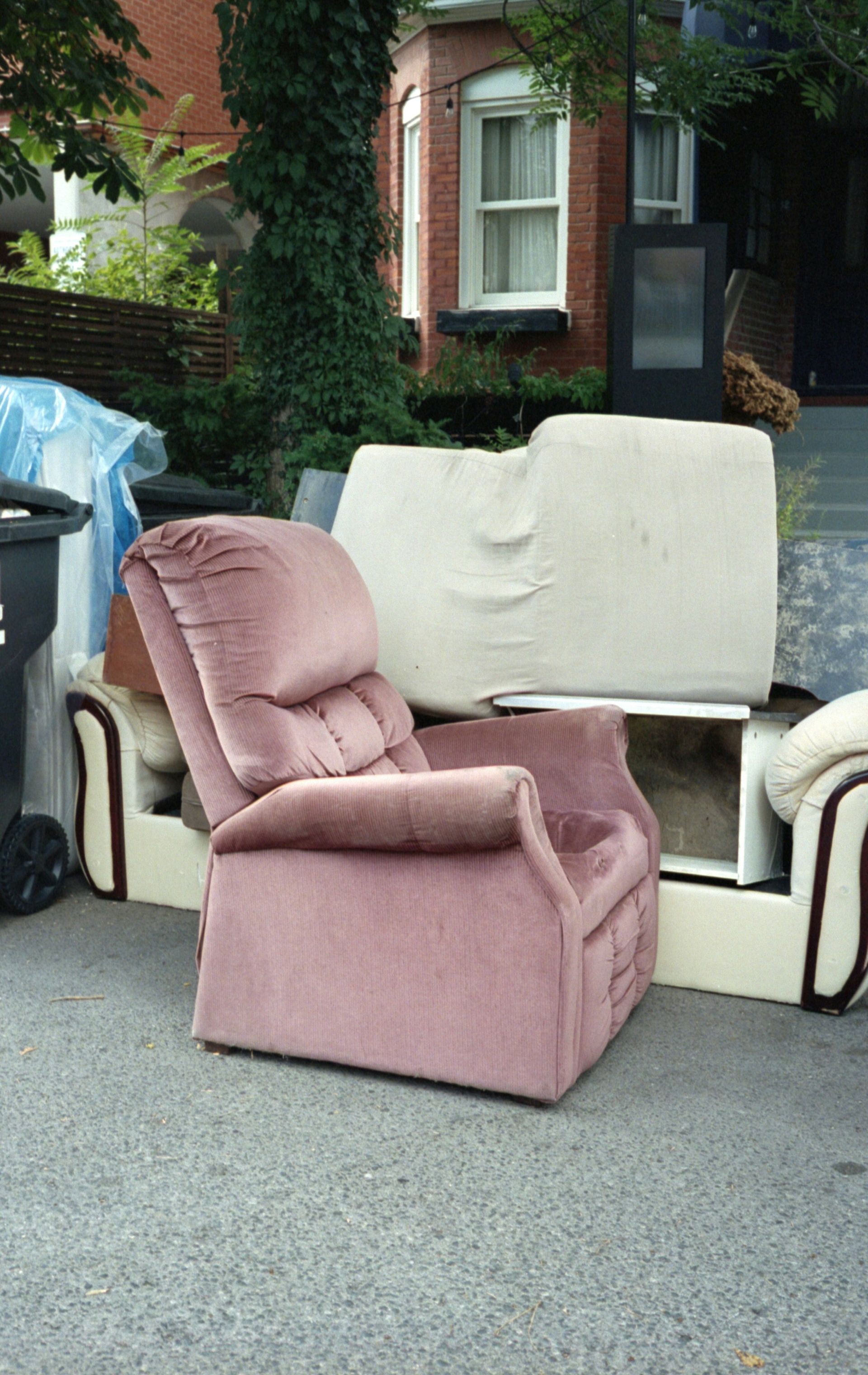 pink sofa chair beside trash bin